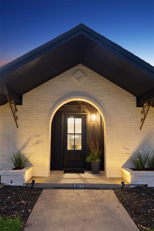 Arched entryway with a dark-paneled door and transom window