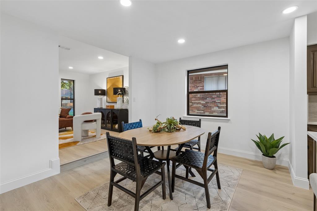 Open-concept dining area featuring recessed lighting, wood-finish flooring, and a large window with black trim