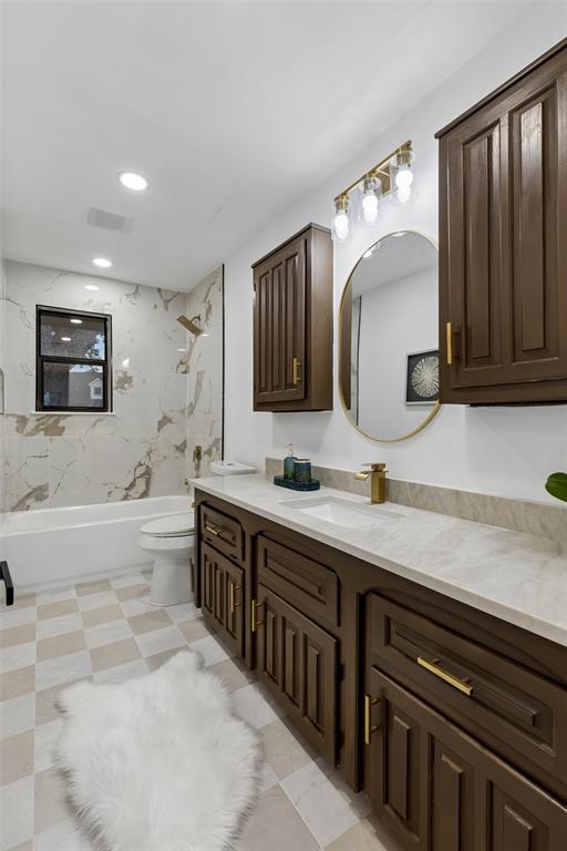 Dual wood-finish vanity with a light-toned countertop, integrated sink, and a gold-finish faucet