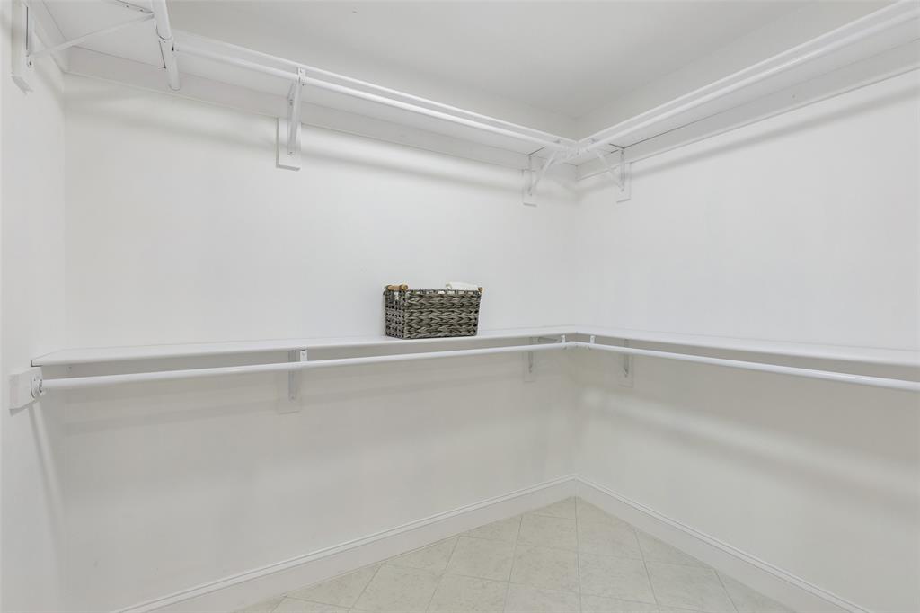Built-in shelving with hanging rods and a tile floor
