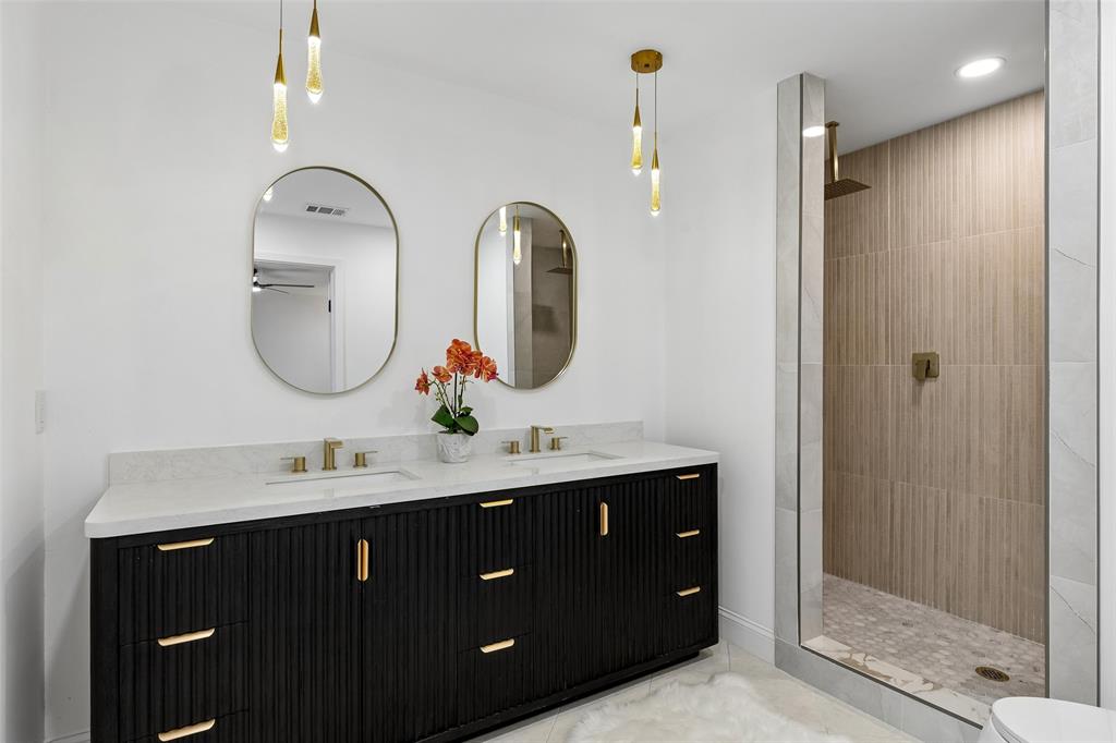 Dual vanity with a fluted dark wood-finish cabinet and gold-tone hardware