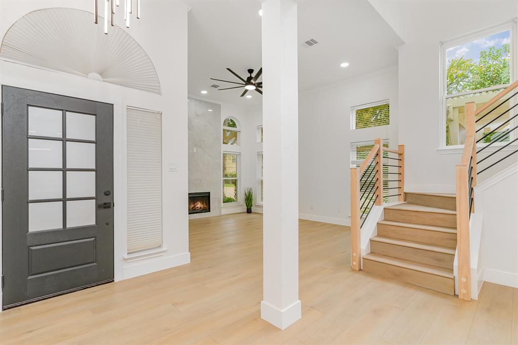 Entrance foyer featuring a high ceiling, a premium fireplace, and light hardwood / wood-style flooring