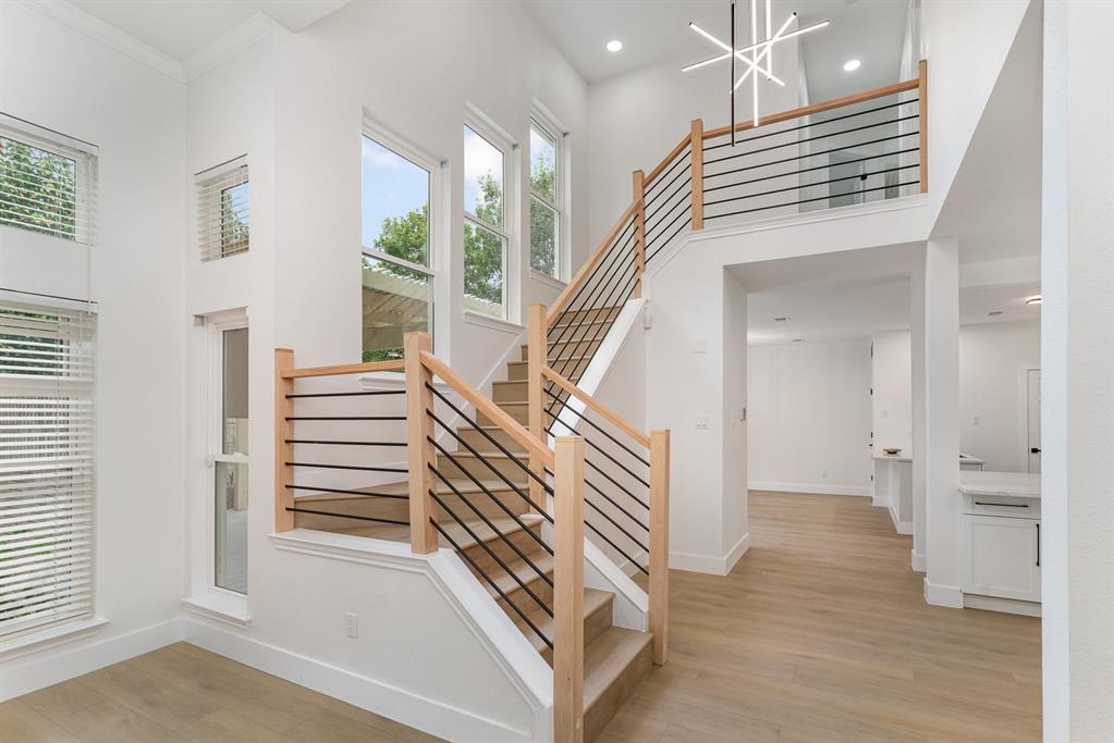 Stairway featuring a towering ceiling, hardwood / wood-style floors, and plenty of natural light