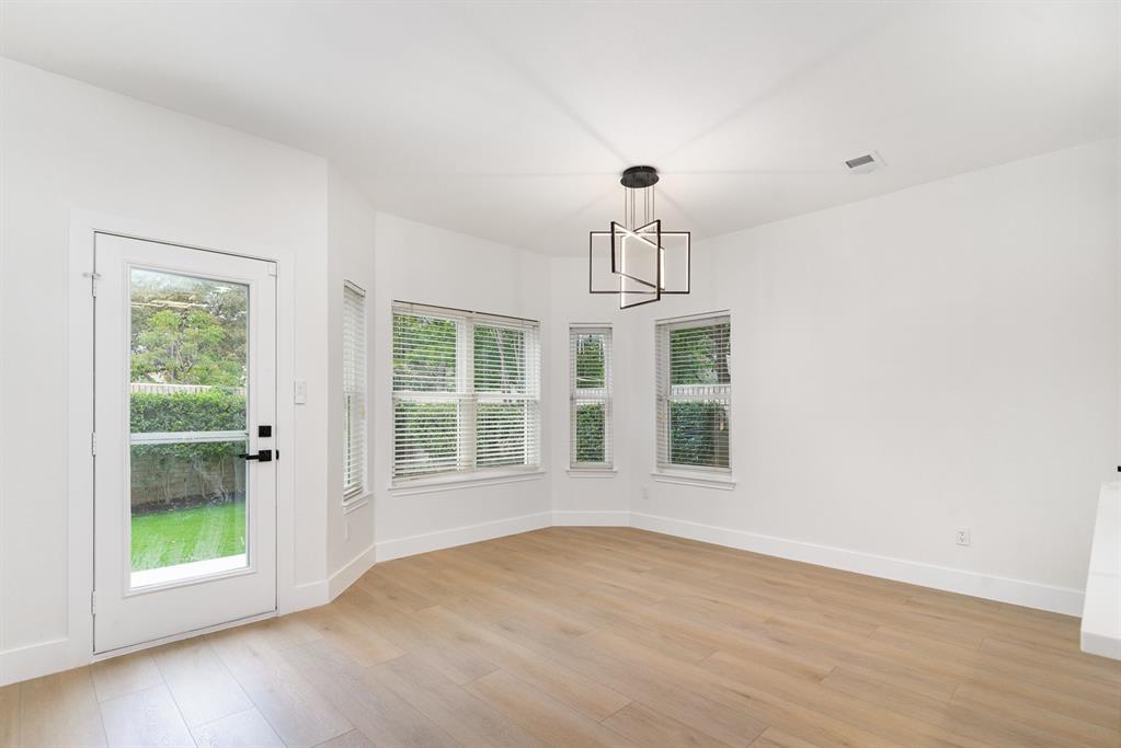 Unfurnished dining area featuring light wood-type flooring and a notable chandelier