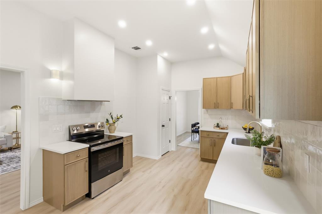 Kitchen featuring wood-finish cabinetry, stainless steel range, white subway tile backsplash, light countertops, and wood-finish flooring
