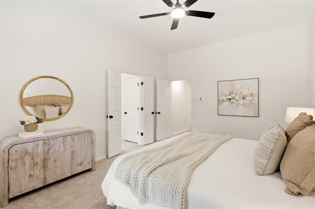 White walls, carpet flooring, a ceiling fan with light, and bi-fold doors