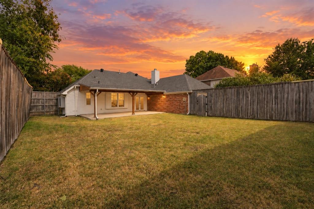 Expansive backyard featuring a covered patio, concrete slab, and privacy fencing