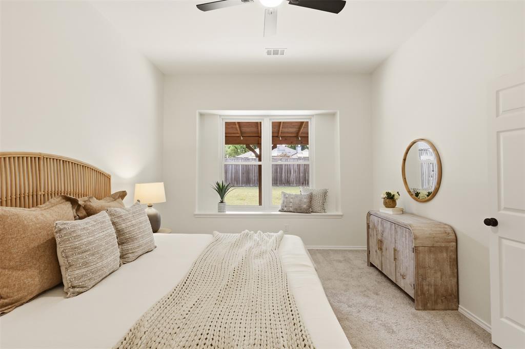 Vaulted ceiling, ceiling fan, window seat, recessed window, and light-colored carpeting