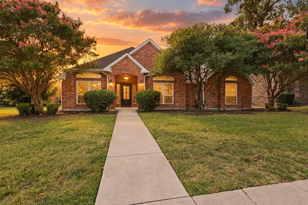 Brick exterior, front walkway, established landscaping, arched entryway, and multiple windows