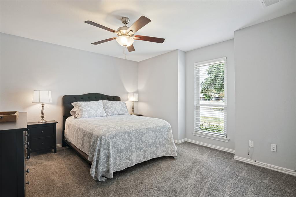 Neutral wall paint, ceiling fan with light fixture, window with blinds, and carpet flooring