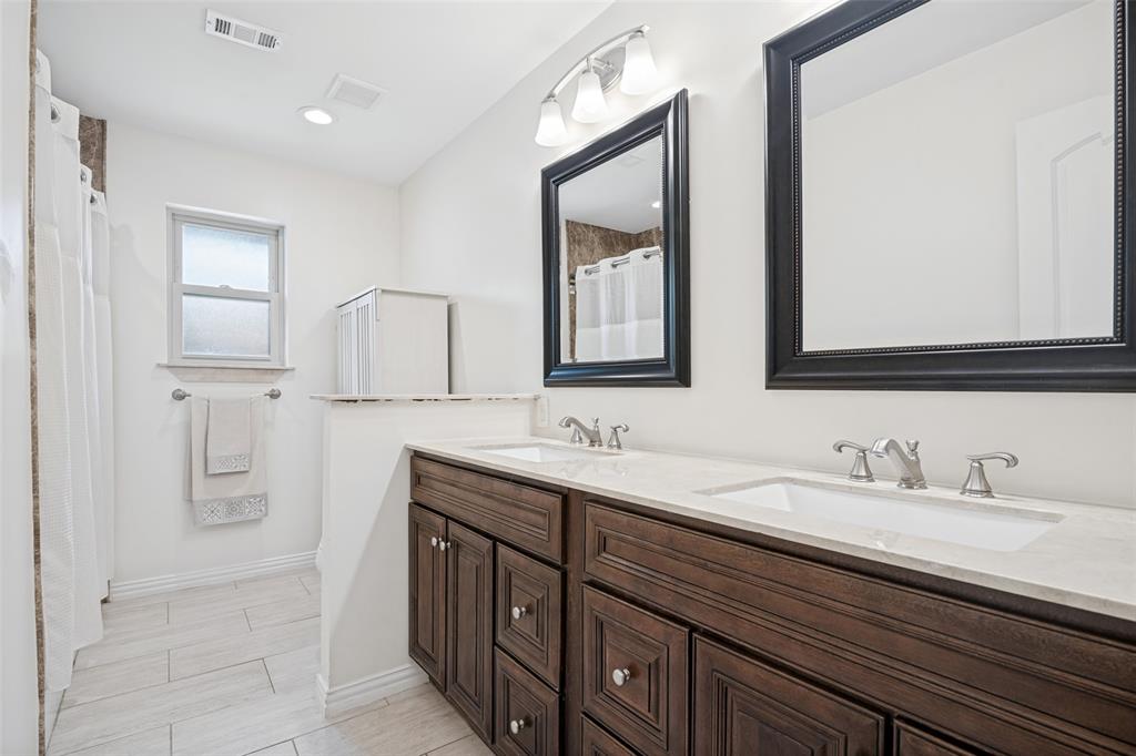 Double vanity with wood-finish cabinetry and light-toned countertops