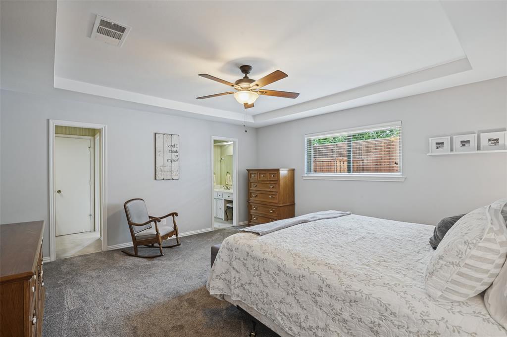 Tray ceiling with a ceiling fan, light gray wall paint, window with blinds, and gray carpet flooring