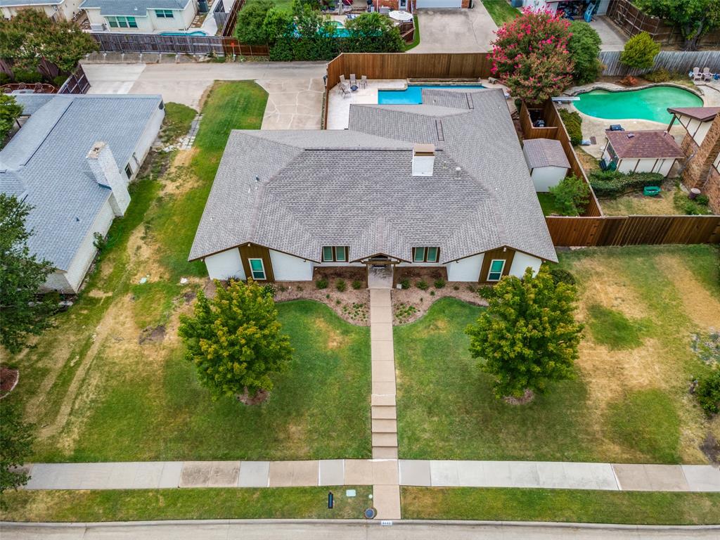 Front yard with a concrete walkway, mature trees, and landscaping