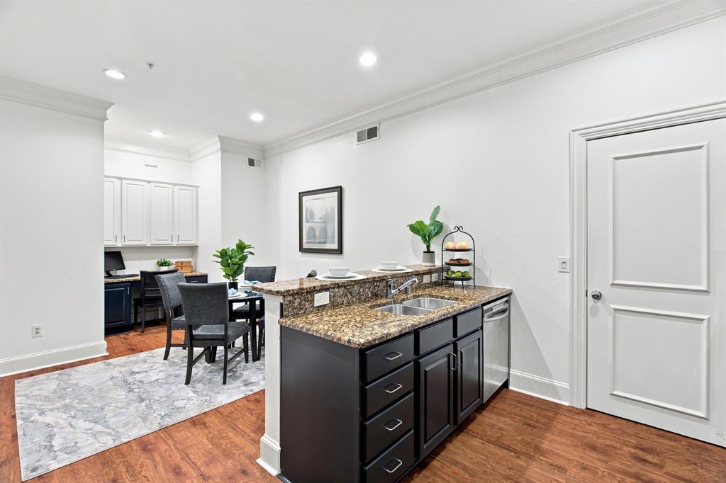 Kitchen featuring dark wood-finish cabinetry, a dual basin stainless steel sink, and a dishwasher