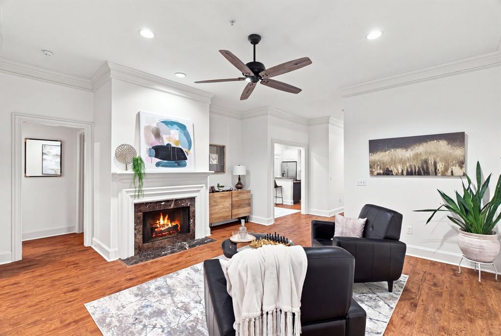 Wood-finish flooring throughout, featuring a fireplace with a stone surround and white mantel