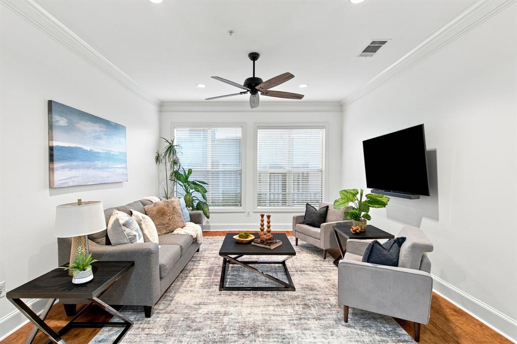Bright, open living room featuring hardwood flooring, recessed ceiling lighting, and a ceiling fan