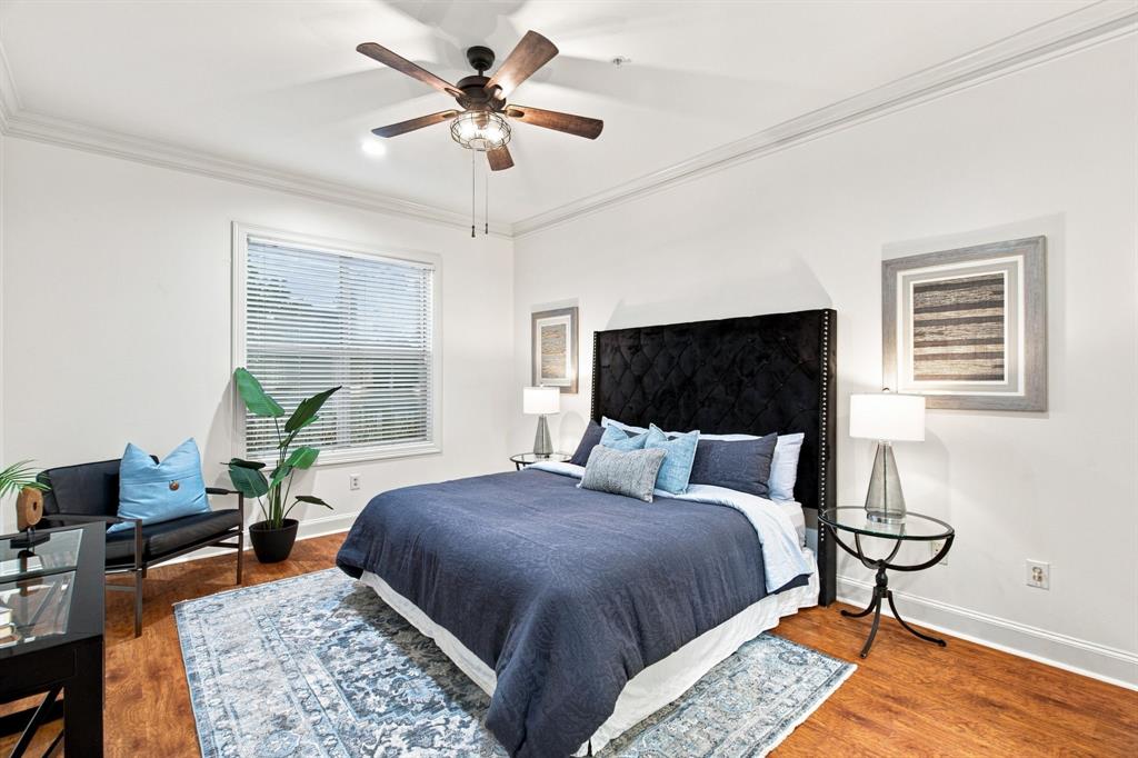 Primary bedroom with ensuite, wood-finish flooring, crown molding, and a ceiling fan with integrated lighting