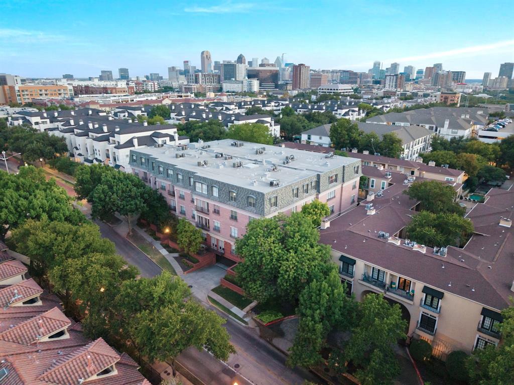 Aerial perspective showcasing multiple residential buildings, including a prominent pink-hued structure with multiple balconies and a mansard-style roof