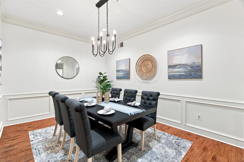 Crown molding and wainscoting paneling complement the wood-finish flooring