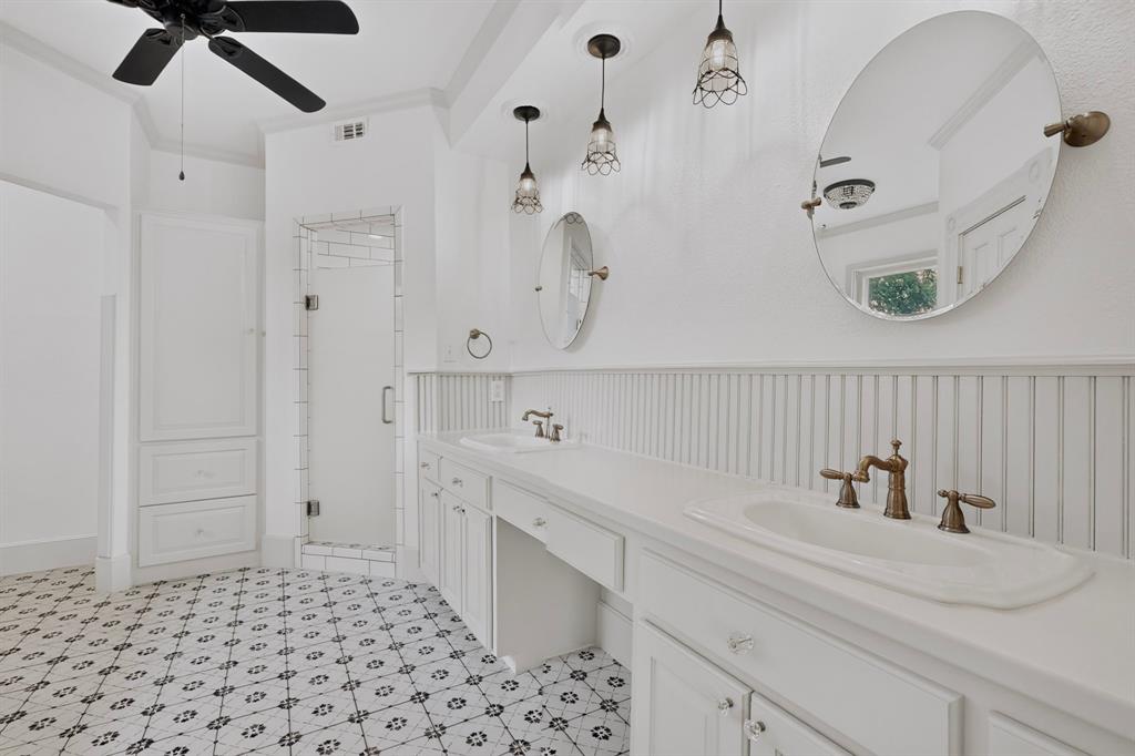 Dual vanity with integrated sinks, custom white cabinetry, and beadboard wainscoting