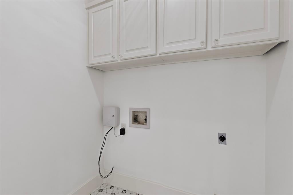 White cabinetry, patterned floor tiles, light-toned walls