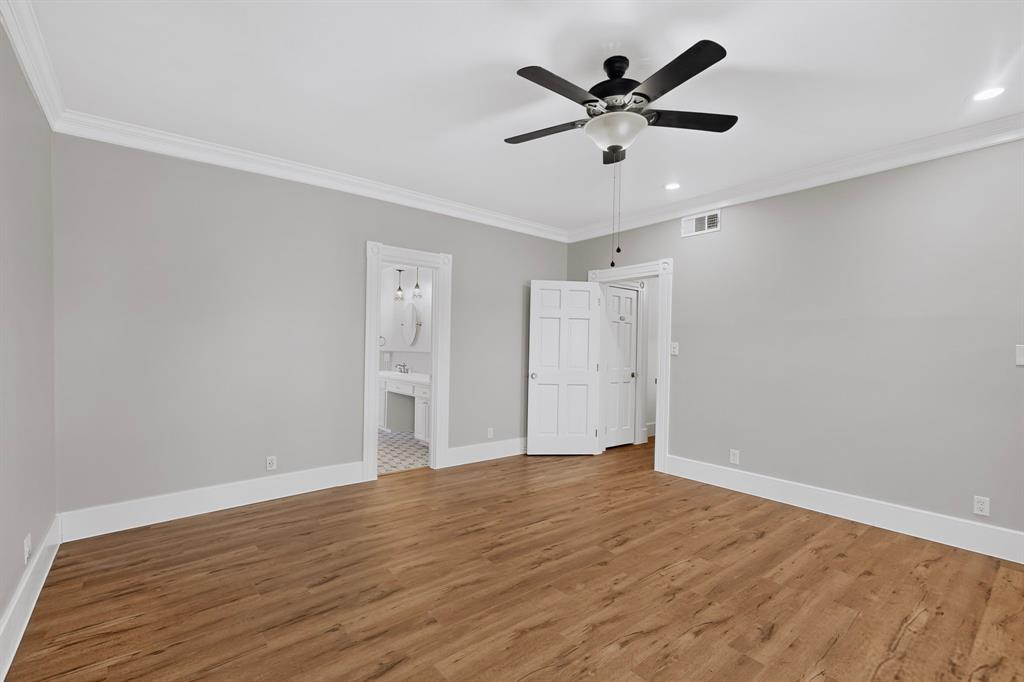 Wood-finish flooring, crown molding, ceiling fan, recessed lighting, and panel doors