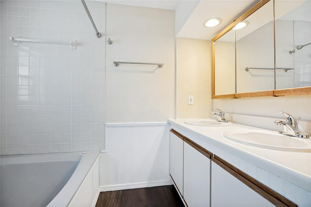 Dual basin vanity with white cabinetry and wood-finish pulls