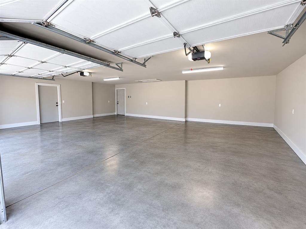 Spacious garage with light grey painted walls and a smooth concrete floor