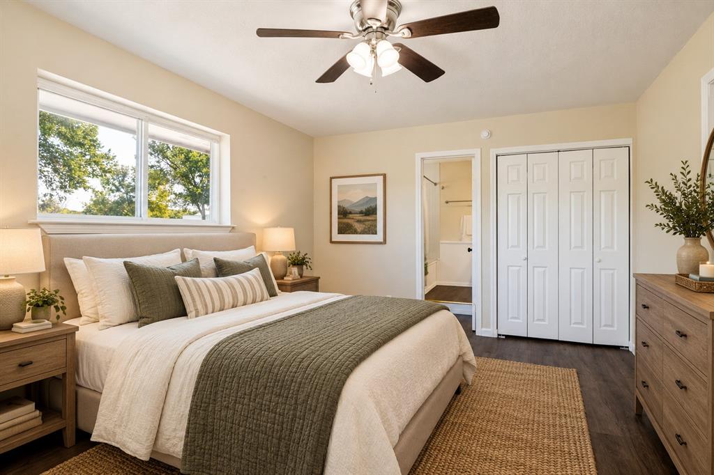 Window with outdoor scenery, ceiling fan with light fixture, wood-finish flooring, bi-fold closet doors, and recessed lighting