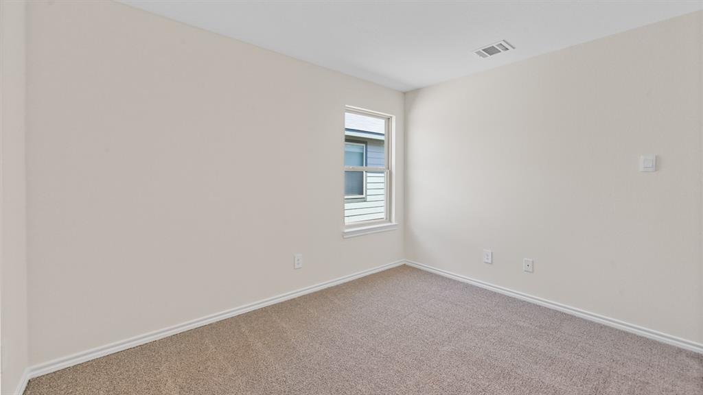 Neutral-toned carpeted room featuring a single window and light-colored walls