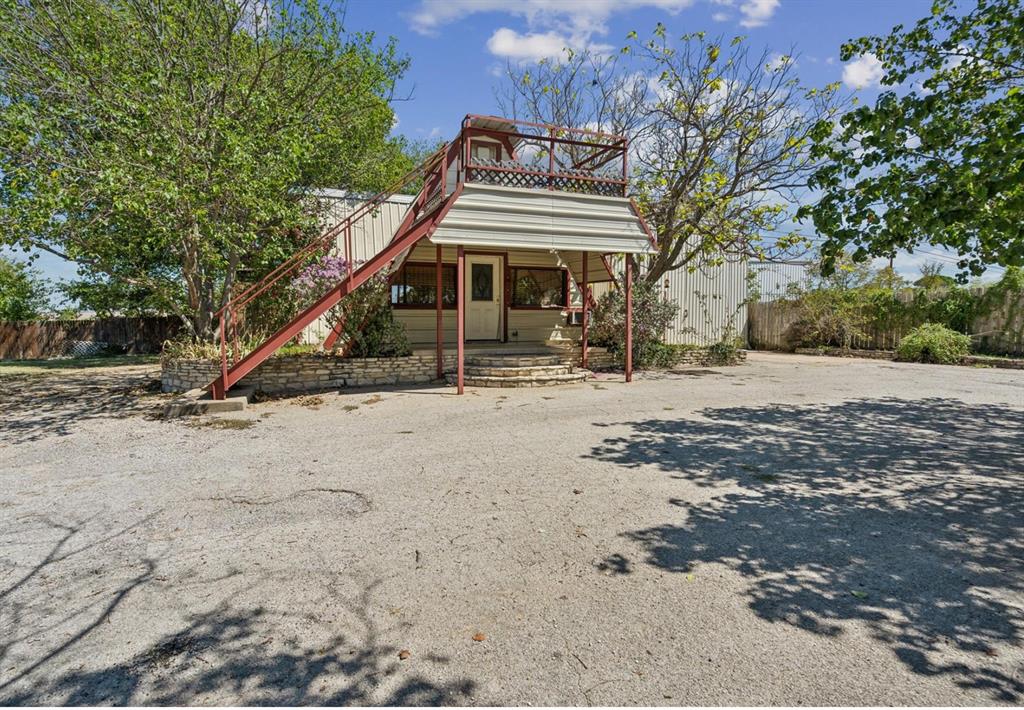 Rear view of house featuring stairs and fence
