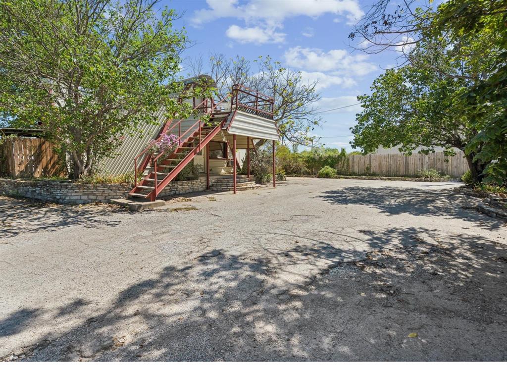 View of yard featuring fence, stairs, and a deck