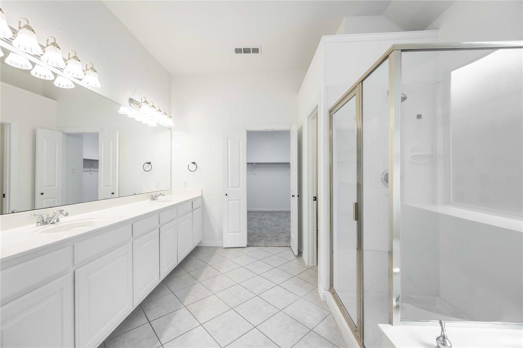 Dual vanity with extensive countertop space, individual sinks, and overhead lighting
