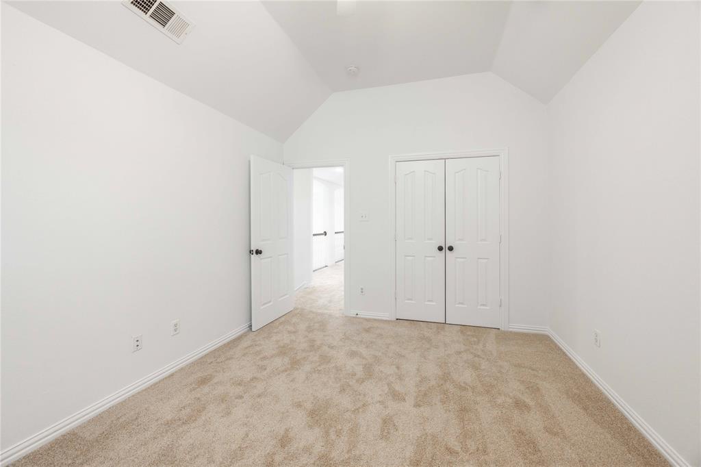 Vaulted ceiling, neutral tone walls, carpeted flooring, paneled interior doors, and baseboard molding