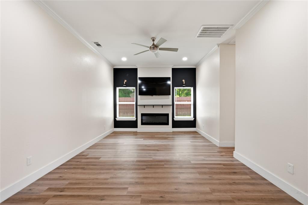 Spacious living area featuring wood-finish flooring, recessed lighting, and a ceiling fan