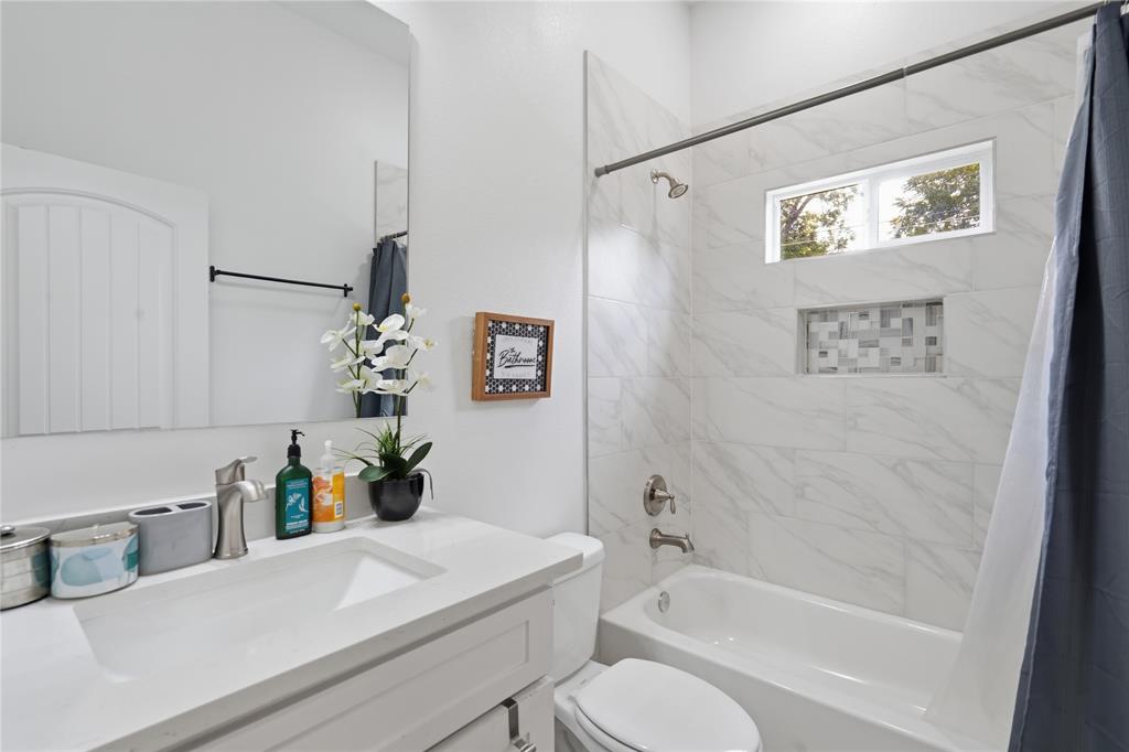 Bathroom featuring a single vanity with an integrated sink and brushed nickel faucet