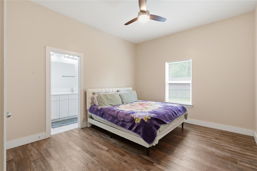 Bedroom featuring wood-finish flooring, a contemporary ceiling fan with integrated lighting, and a single window