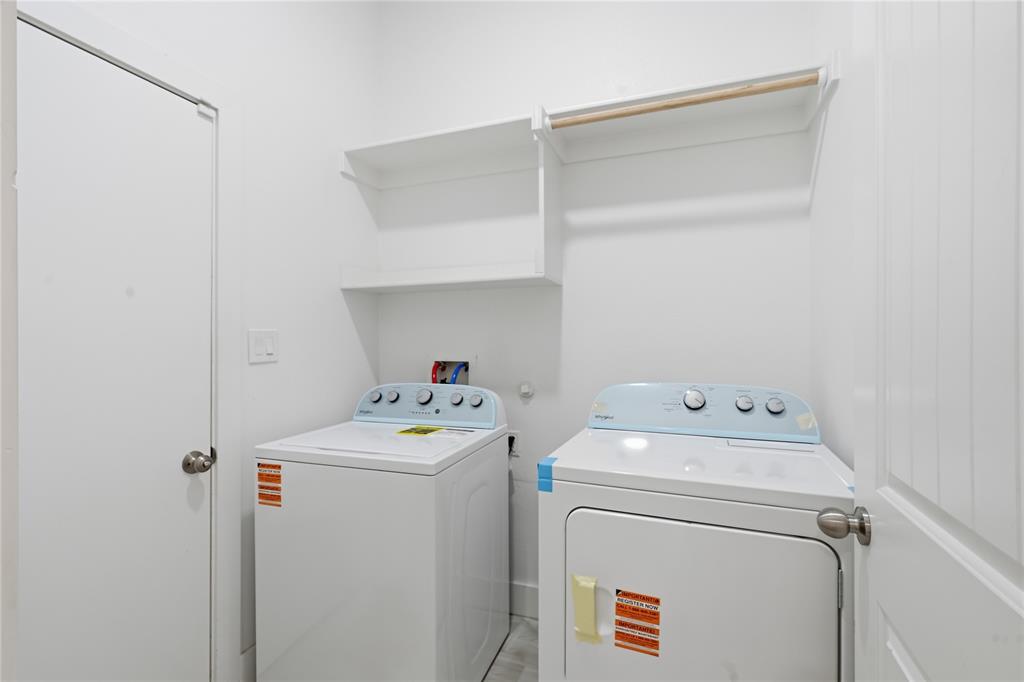 Dedicated laundry area featuring white walls, two built-in shelves, and a wooden hanging rod