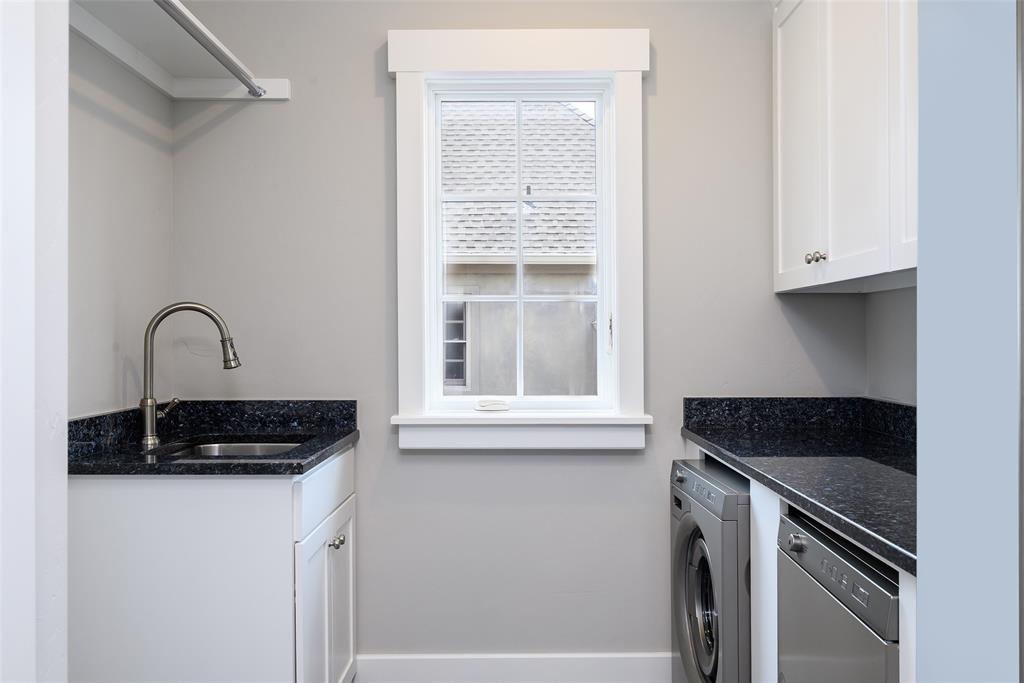 Utility room with white shaker cabinetry, dark speckled countertops, and a single-basin stainless steel sink with a gooseneck faucet