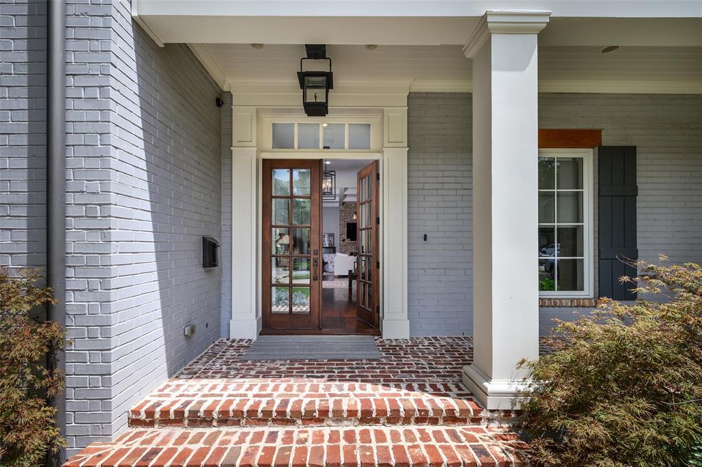 Painted brick exterior with a columned front porch, brick steps, and wood-finish French doors Painted brick exterior with a columned front porch, brick steps, and wood-finish French doors