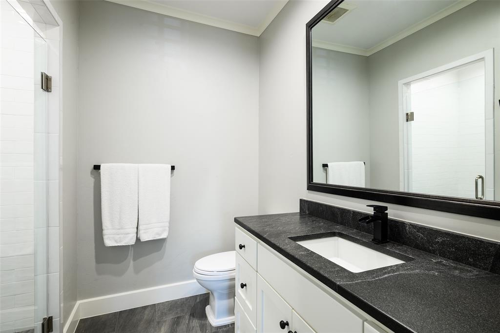 Glass-enclosed shower with white tiled walls