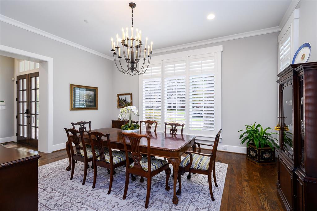 Recessed lighting, crown molding, wood-finish flooring, white window shutters, and a dark bronze chandelier Recessed lighting, crown molding, wood-finish flooring, white window shutters, and a dark bronze chandelier