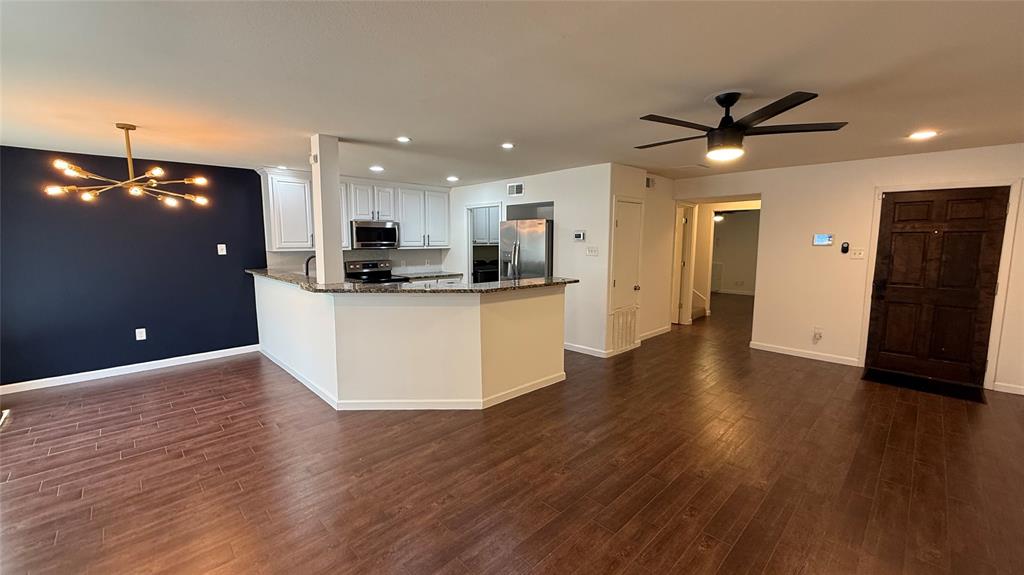 Open-concept living area with wood-finish flooring, a contemporary chandelier, recessed lighting, and a ceiling fan