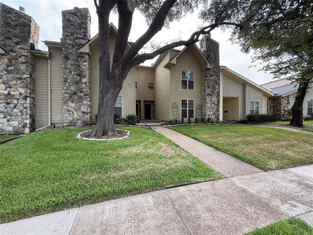 Exterior featuring stone veneer accents, stucco siding, a mature tree, an attached covered entryway, and a concrete walkway Exterior featuring stone veneer accents, stucco siding, a mature tree, an attached covered entryway, and a concrete walkway