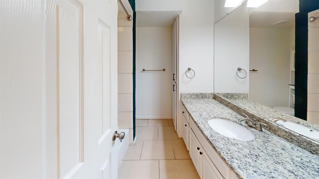 Double vanity with granite-style countertop, dual undermount sinks, and full-width mirror