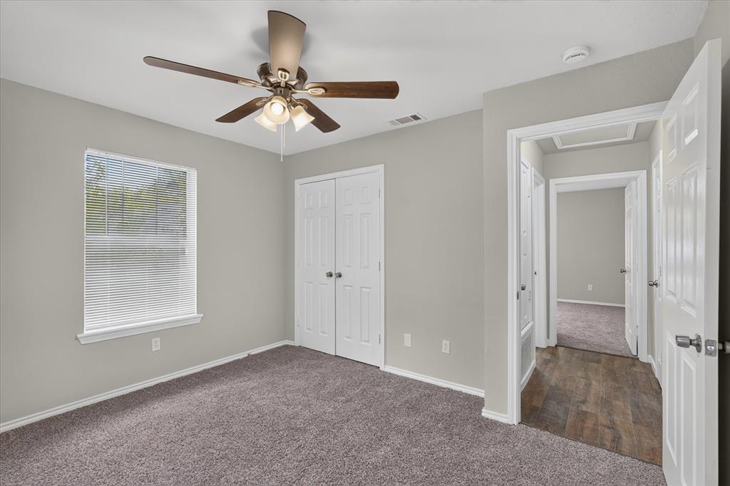 Carpeted room with a ceiling fan light fixture
