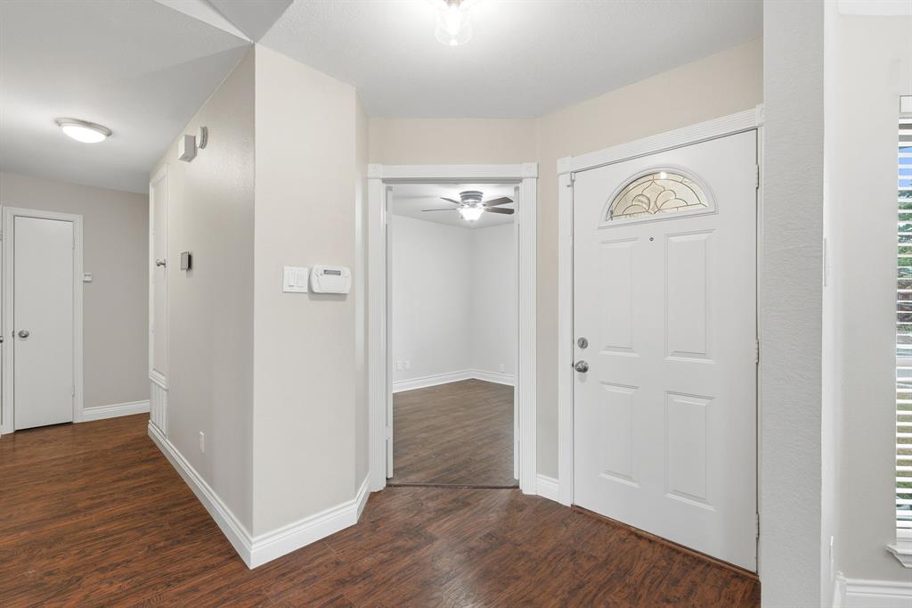 Entry area with double doors to secondary bedroom with ceiling fan and closet.
