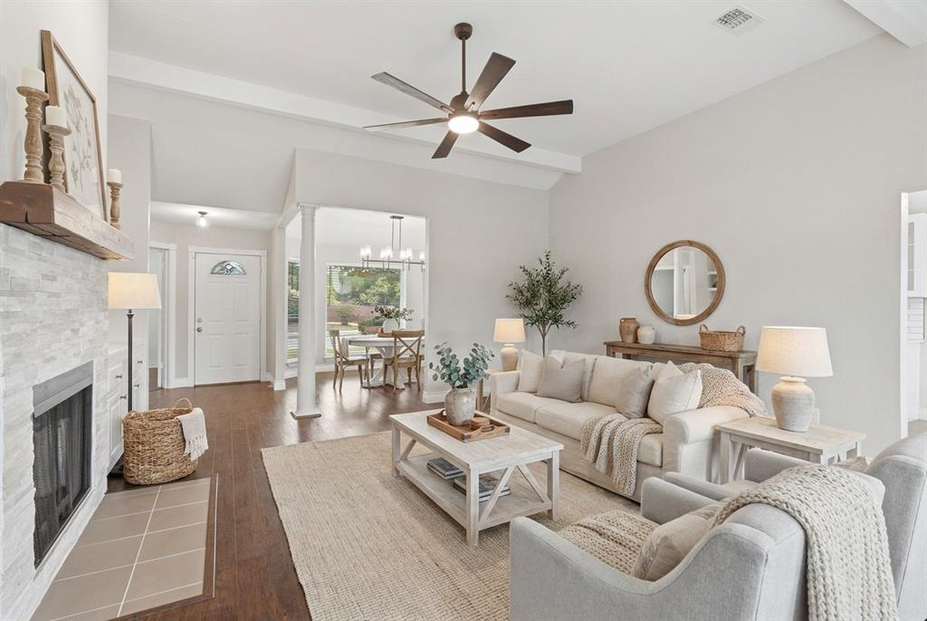 Virtually staged. Living room with new ceiling fan, wood burning fireplace and built-in storage area with quartz countertops.