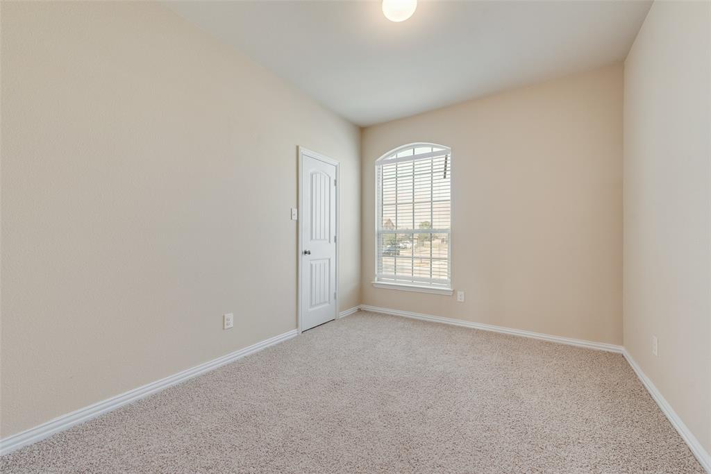 Arched window with blinds, vaulted ceiling, and neutral carpet flooring