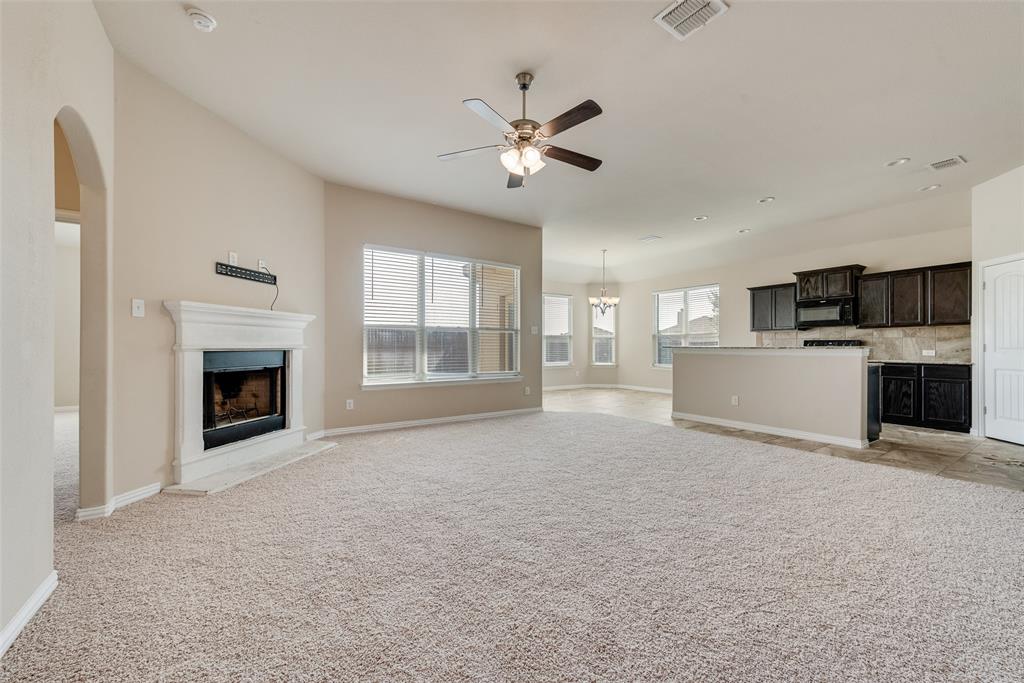Expansive living area with vaulted ceilings, a fireplace, and large windows Expansive living area with vaulted ceilings, a fireplace, and large windows